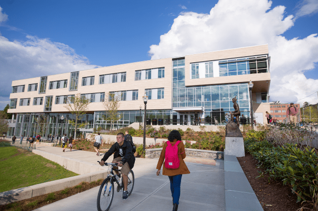 student riding a bike on UMass campus