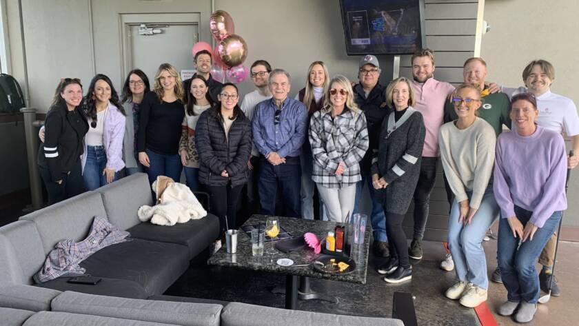 Employees posing for a group photo at top golf