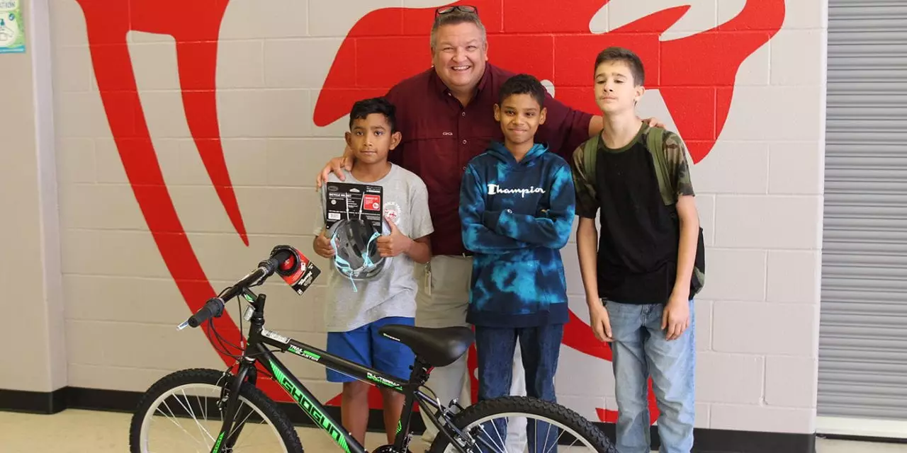 round rock ISD teacher with Students standing behind a bike