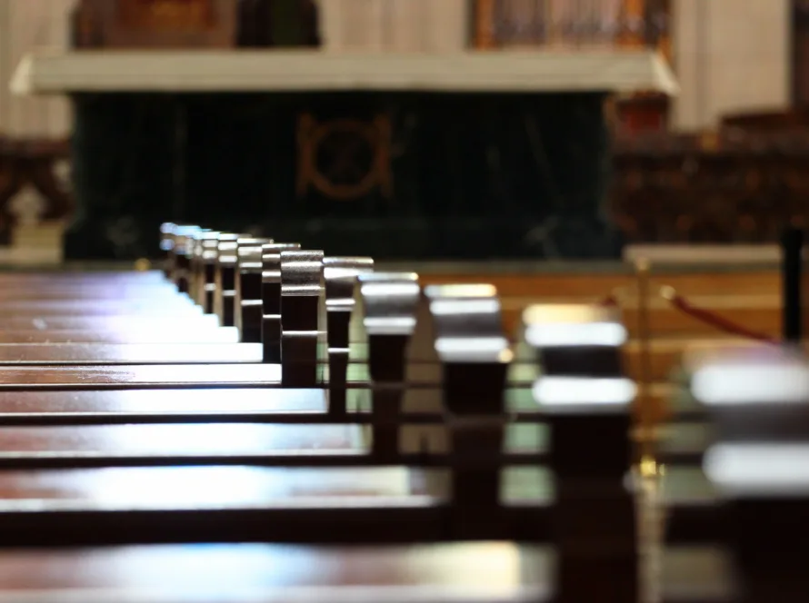 Rows of church benches. Sunlight reflection on polished wooden pews. Selective focus.