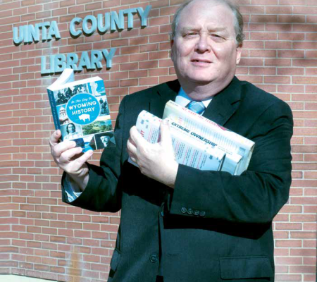 unita county library man holding book in front of the unita county library